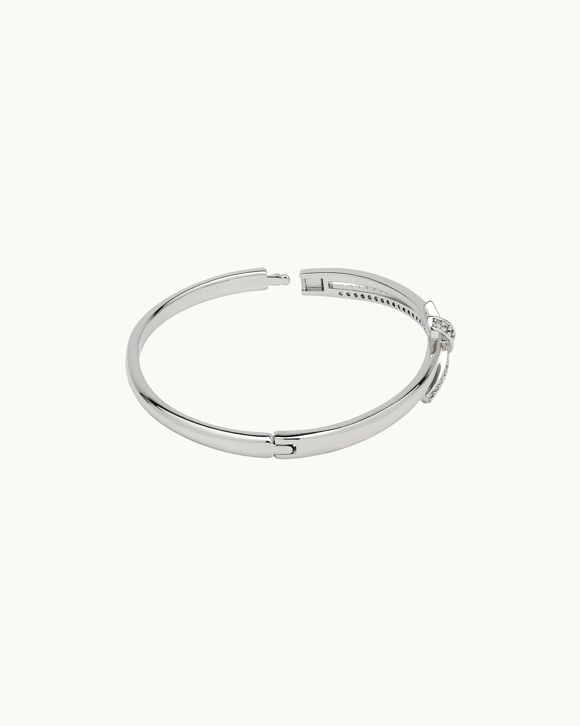 Polished hinged bangle with pavé cubic zirconia knot detail in silver, by Kaleido Jewellery Singapore.
Polished hinged bangle with pavé cubic zirconia knot detail in gold, by Kaleido Jewellery Singapore.