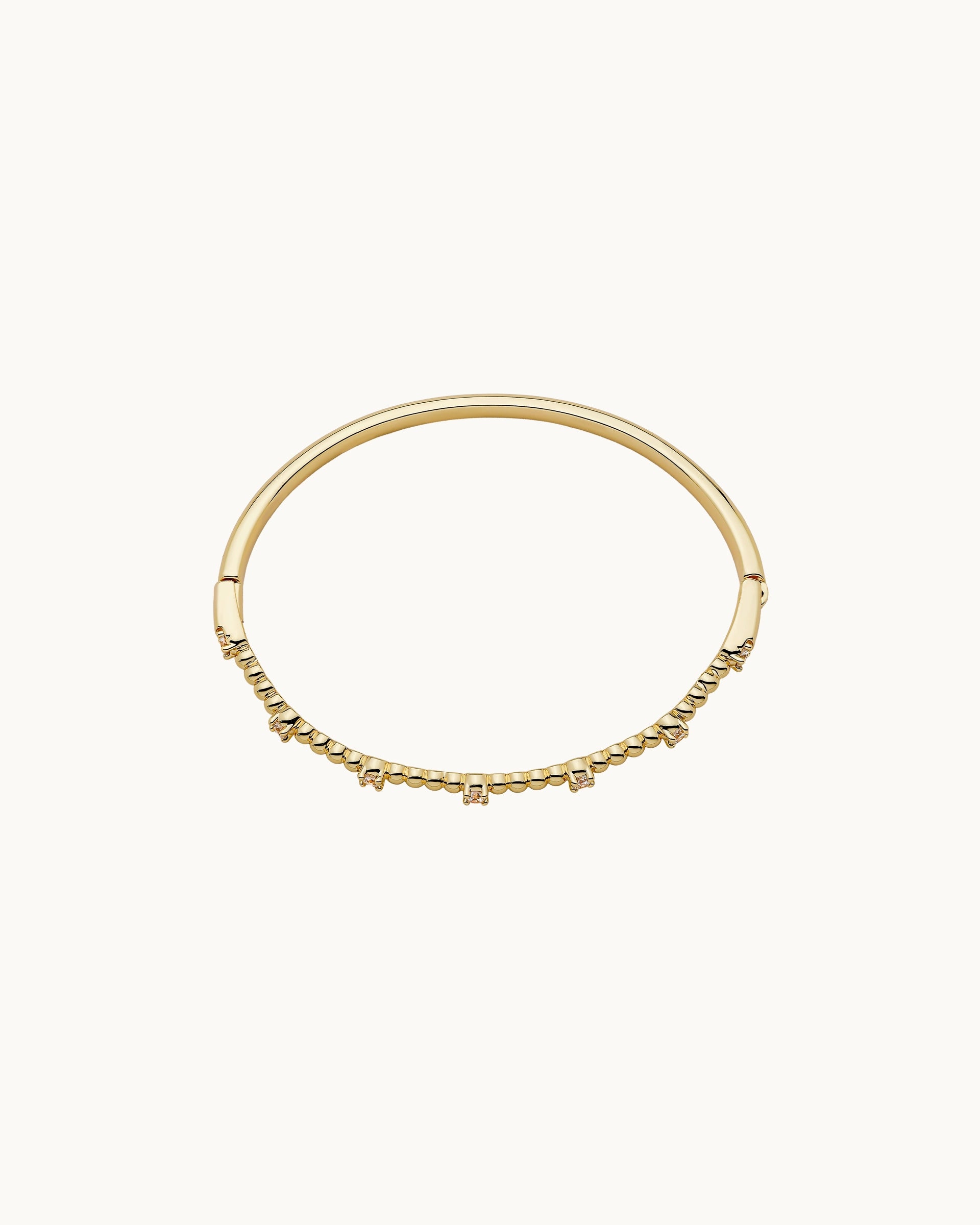Polished spherical bead and round cubic zirconia solitaire hinged bangle in silver, by Kaleido Jewellery Singapore.
Polished spherical bead and round cubic zirconia solitaire hinged bangle in gold, by Kaleido Jewellery Singapore.